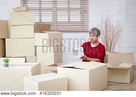 Fat Man With White Hair Is Packing Products Into Paper Boxes For Delivery The Concept Of Small Entre