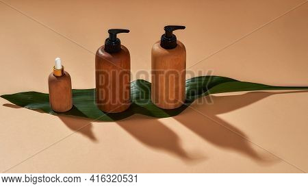 Set Of Wooden Bottles Or Containers Of Different Sizes On Green Leaf Isolated On Beige Background. Z