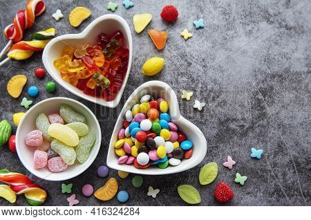 Multicolored Candies, Dragees And Lollipops On A Black Background