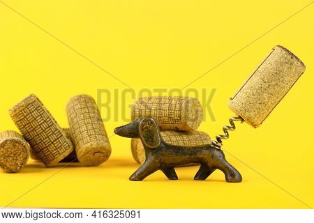 Close-up Of A Group Of Antique Dated Wine Corks And An Old Corkscrew, In The Form Of A Dachshund Dog