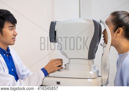 Selective Focus At Optometry Frame Equipment. While Doctor Using Penlight And Subjective Refraction 