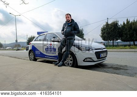 Kemerburgaz, Istanbul, Turkey - 03.19.2021: Handsome Instructor Of Driving Test Car In Turkey Standi