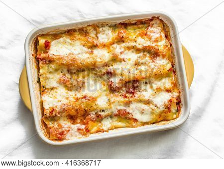 Cannelloni With Spinach And Ricotta Baked With Tomato Sauce And Mozzarella On A Light Background, To