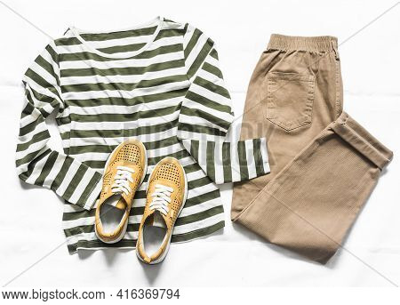 Women's Slouchy Pants, A Long Sleeve Striped Cotton T-shirt And Suede Sneakers On A Light Background