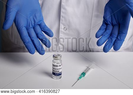 Doctor Presents Covid Vaccine And Syringe. Hospital Medic Man Offers To Take Vaccine Inoculation Aga