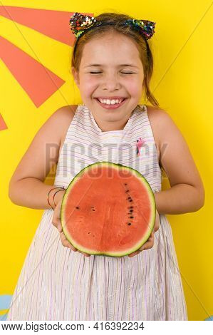 A Little Girl Of European Appearance With A Juicy Watermelon. Child On A Bright Summer Background. N