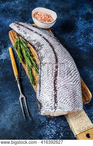 Fresh Raw Grenadier Macrurus White Fish On A Wooden Cutting Board. Blue Background. Top View