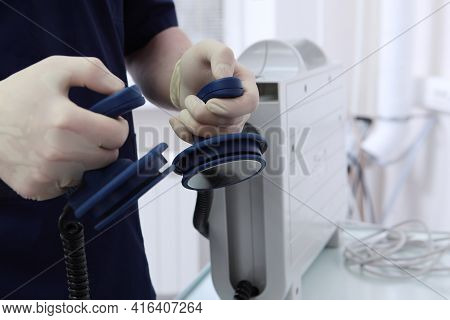 Preparing For Defibrillation.resuscitator Holds Electrodes In His Hands To Restore The Heart Rhythm.