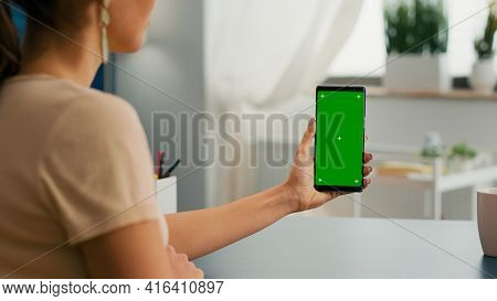 Back View Of Freelencer Holding Chroma Key Green Screen Mock Up Smartphone