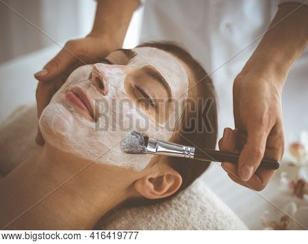 Beautiful Brunette Woman Enjoying Applying Cosmetic Mask With Closed Eyes Comfortable And Blissful. 