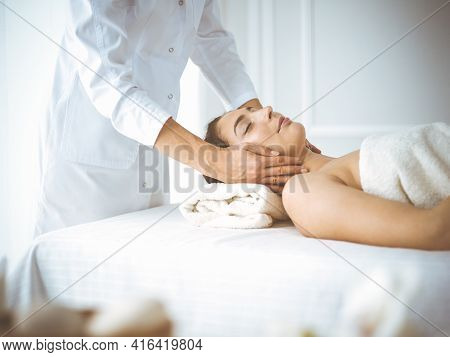 Beautiful Brunette Woman Enjoying Facial Massage With Closed Eyes Comfortable And Blissful. Relaxing