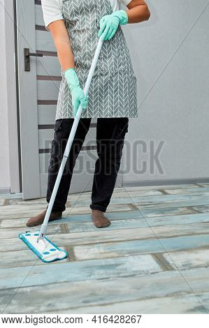 Bearded Man In Gloves With Mop In Hand Cleaning Floor In The House