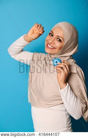 An Oriental Woman In A Hijab Smiles A Toothy Smile At The Camera And Uses A Dental Floss, Posing Aga