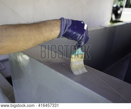 Worker Applies Waterproofing With A Small Brush