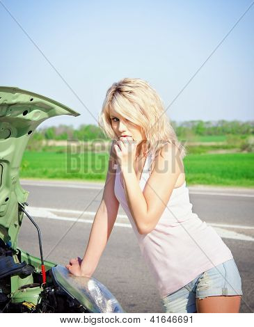 Blond meisje Stands in de buurt van de gebroken auto