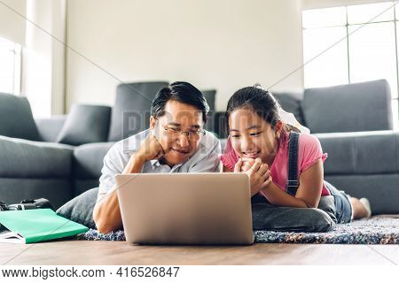 Father And Asian Kid Little Girl Learning And Looking At Laptop Computer Making Homework Studying Kn