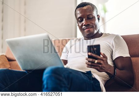 Young Black African Man Relaxing Using Laptop Computer Working And Video Conference Meeting At Home.