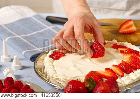 Woman Baker Stacks Strawberries On Meringue Strawberry Cake Base. Homemade Strawberries Cake Made Fr