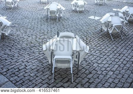 Empty Downtown Restaurant Terrace With Folded Furniture. Covid-19 Crisis At Hostelry Concept