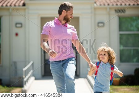 American Father And Son Walking Trough School Park