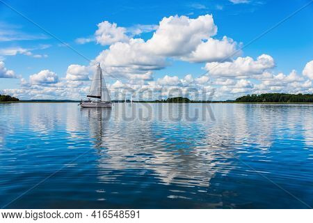 Sailing Yacht In The Lake With Gloomy Sky Before The Rain. Yacht Sailing On The Lake Against A Blue 