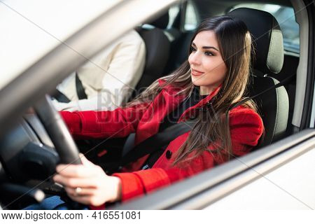 Young smiling woman driving her car