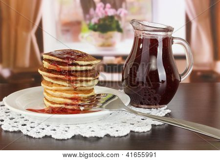 หวาน pancakes บนแผ่นกับแยมบนโต๊ะในห้อง