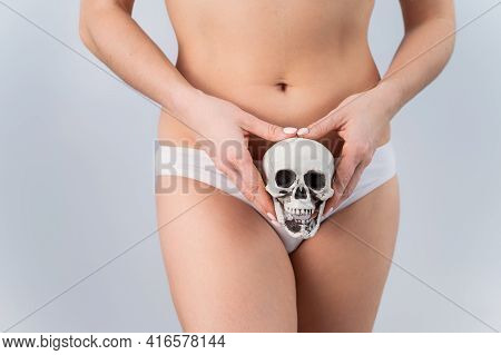 Faceless Woman In Underpants Holding A Skull On A White Background.