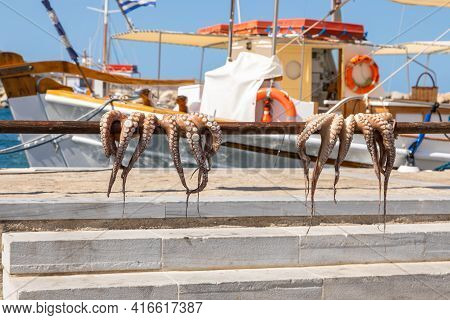 Naoussa, Paros Island, Greece - 27 September 2020: Octopus Hanging Up On A Stick To Dry At The Quay.