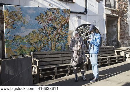 Moscow, Russia - 11 April 2021, Man And Woman Are Standing The Old Street In The Art Quarter Of Hitr