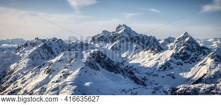 Aerial View From Airplane Of Blue Snow Covered Canadian Mountain Landscape In Winter. Bright Sunny B