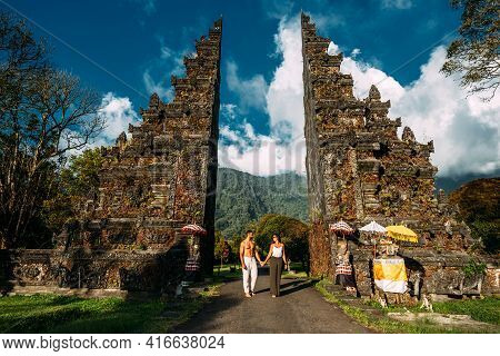 Traveling Couple In Bali. Happy Couple Vacationing In Asian Countries. Couple At The Bali Gate. A Ma