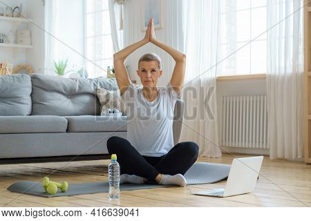 Senior Woman With Closed Eyes, Online Training In Living Room. Exercising With Laptop Watching Fitne
