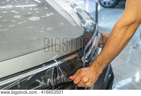 Car Protection Film Or Ppf Process Of Wrapping And Installing On Car Hood By Detailer Worker Hands, 