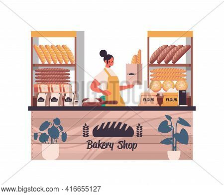 Female Baker Holding Bag With Baguettes Woman In Uniform Selling Fresh Bakery Products In Baking Sho
