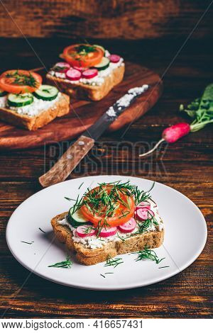 Vegetarian Sandwich With Fresh Sliced Tomatoes, Cucumber And Radish On White Plate