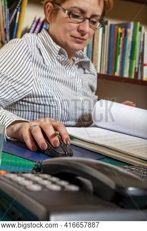 Close-up Of The Hand Of A Woman Telecommuting At Her Desk At The Home. Working At Home Became An Imp