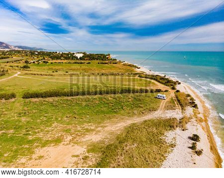 Aerial View. Coastal Landscape With Caravan Wild Camping On Beach Sea Shore. Mediterranean Coast Of 