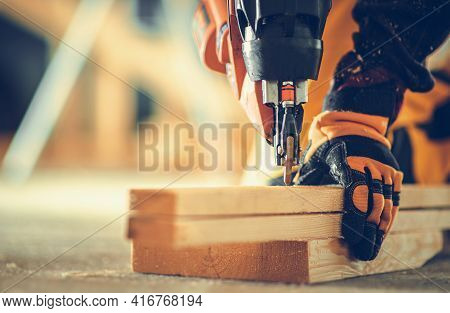 Powerful Nail Gun Construction Job Close Up. Contractor Worker With Power Tool In His Hands.