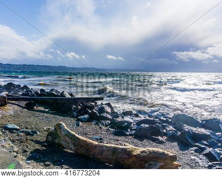 Back Rocks Lin The Shore On A Windy Day At Satlwater State Park In Washington State.