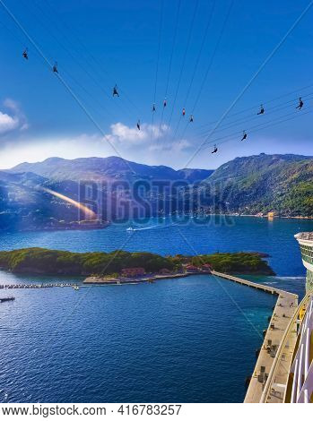 People Flying At High Zipline On Caribbean At Labadee Island At Haiti. The Arial View From Desck Of 