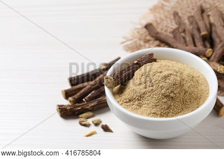 Powder In Bowl And Dried Sticks Of Liquorice Root On White Table, Space For Text