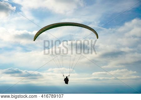 Man Doing Sport, Para-glider In The Clouded Sky. Paragliding Is An Extreme Sport And Recreation. Tor