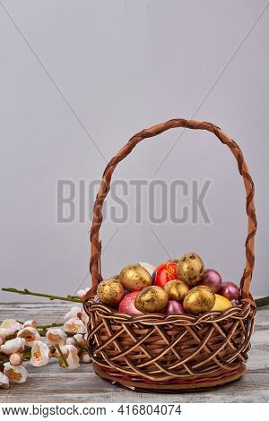 Basket Of Decoratied Easter Eggs And Flowers.