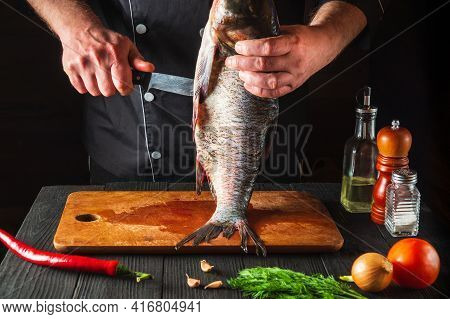 The Chef Is Cleaning A Bighead Carp Fish. Working Environment In The Restaurant Kitchen. Fish Diet C