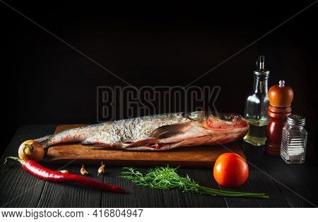 Hypophthalmichthys Or Bighead Carp On A Cutting Board With Vegetables Before Cooking. Raw Peeled Fis