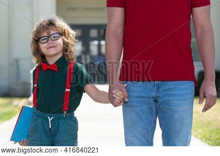 Father Walking Son To School. Parent And Nerd Pupil Of Primary School Schoolboy With Backpack