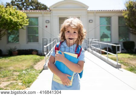 Elementary School And Education. Kid Holding Books From Primary School. Portrait Of Pupil Near Schoo