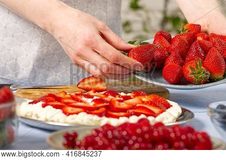 Woman Baker Stacks Strawberries On Meringue Strawberry Cake Base. Homemade Strawberries Cake Made Fr