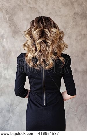 Beautiful Woman Back With Curly Hairdo On Gray Background